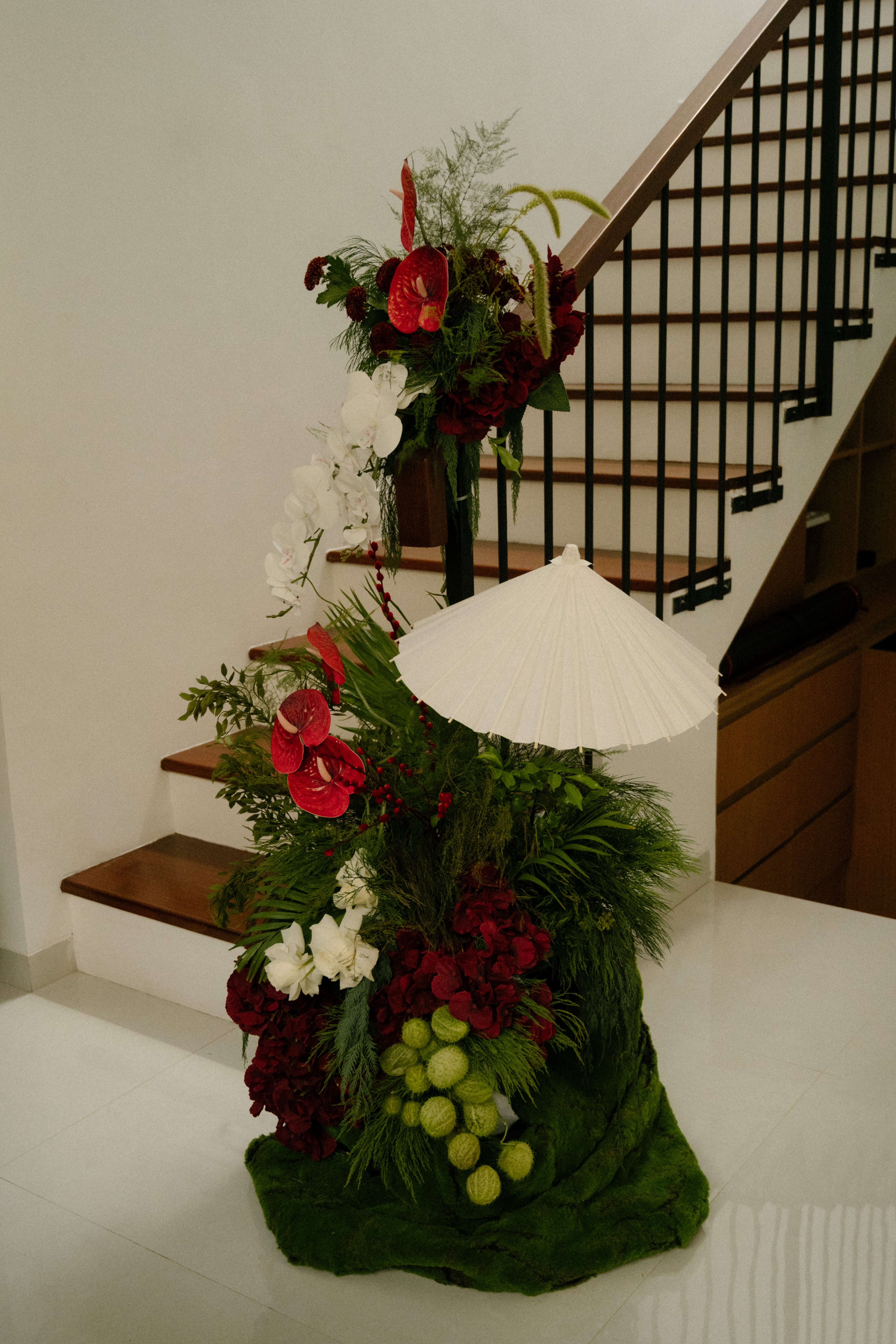 Decorative floral arrangement with a white umbrella on a staircase